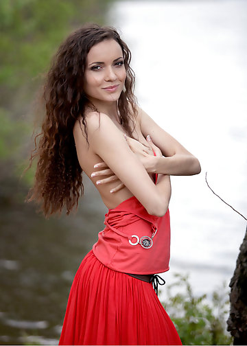 Naked photos of the curly girl taking off red dress in the fresh air