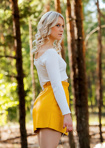 Beautiful blonde with a glass lantern undresses on a picnic in the forest