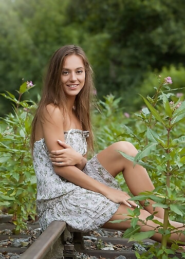 Playful woman undresses by the railway