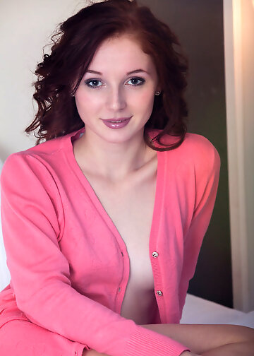 Brunette in pink blouse posing naked on the bed