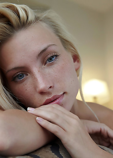 Blonde girl lies naked in bed and looks into camera in pussy pics