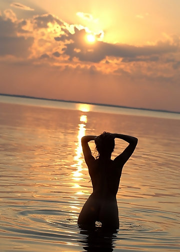 Attractive brunette seductively poses nude in the water