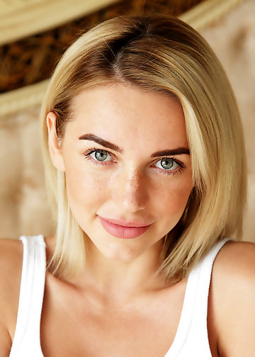 Light-haired naked model has big beautiful boobs and green eyes