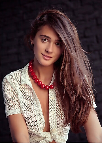 Long-haired woman poses nude on the sofa