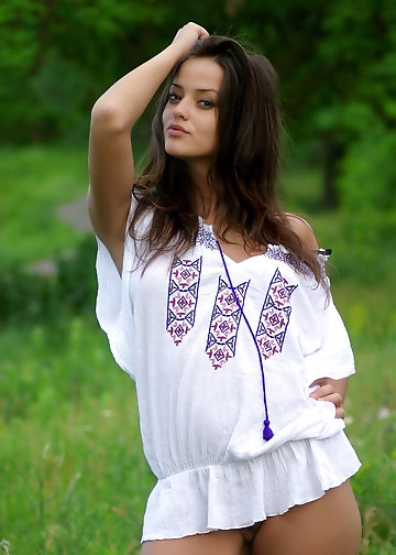 Slutty girl is lying among flowers exposing weather-stained nipples