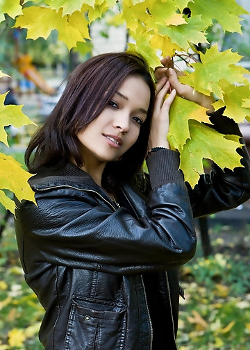 Young woman with dark eyes is happy with advertising rear and peach