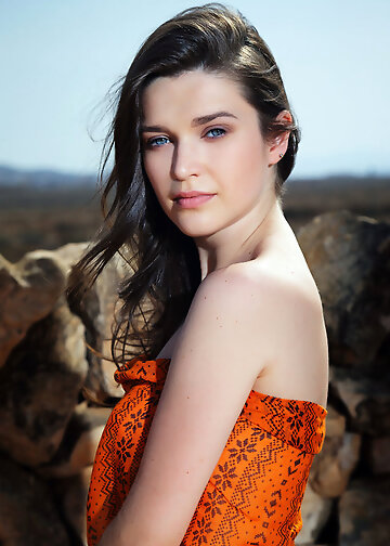 Slutty girl in colorful dress parades small tits and pussy on rocks