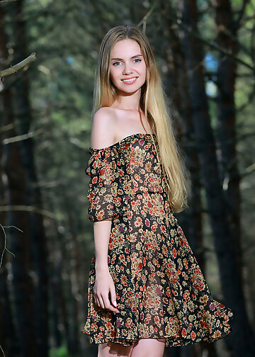 Enticing babe stripping naked while walking in the forest