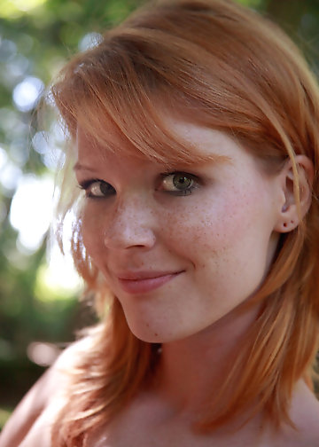 Outdoor pics of slender redhead posing naked in the forest