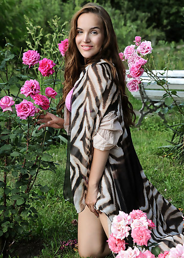 Slender charmer goes into the garden to reveal her sensuality