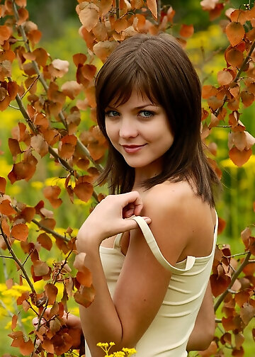 Wild yellow flowers fall all over the brunette's tight pussy and firm boobies